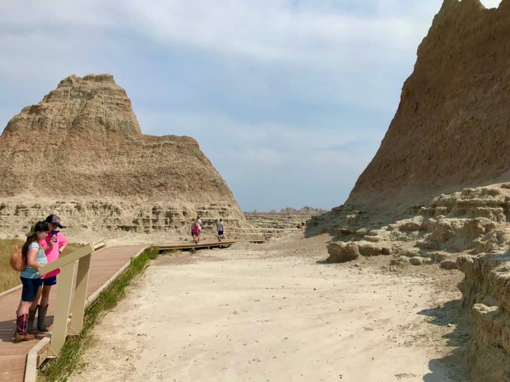 Girls reading sign along trail at Badlands national Park.