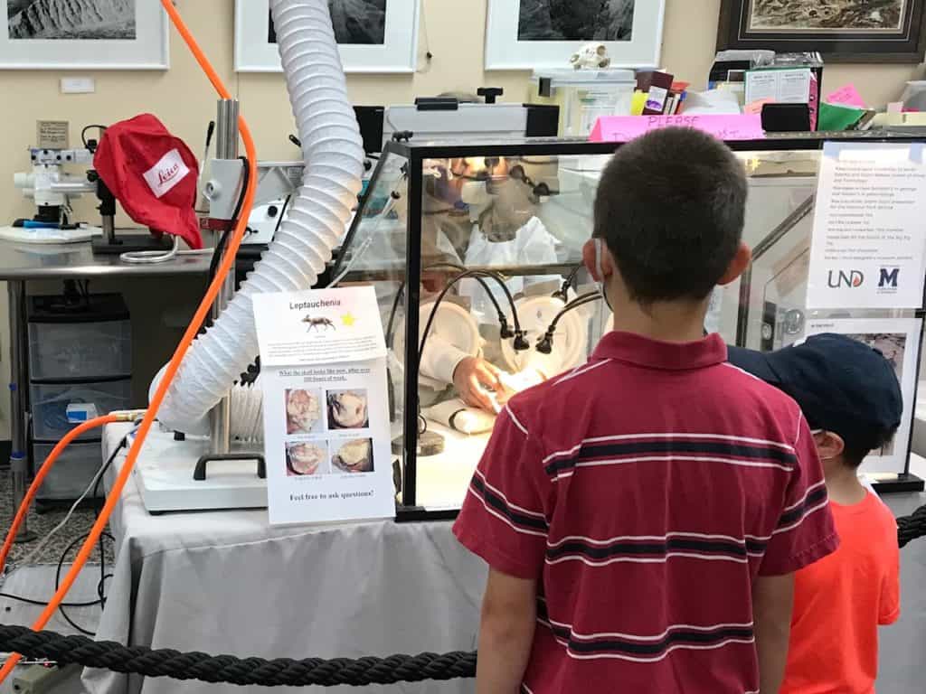 Boys talking with paleontologist at the fossil lab at Badlands NP. Stopping at the fossil lab is a must when driving through Badlands National Park.