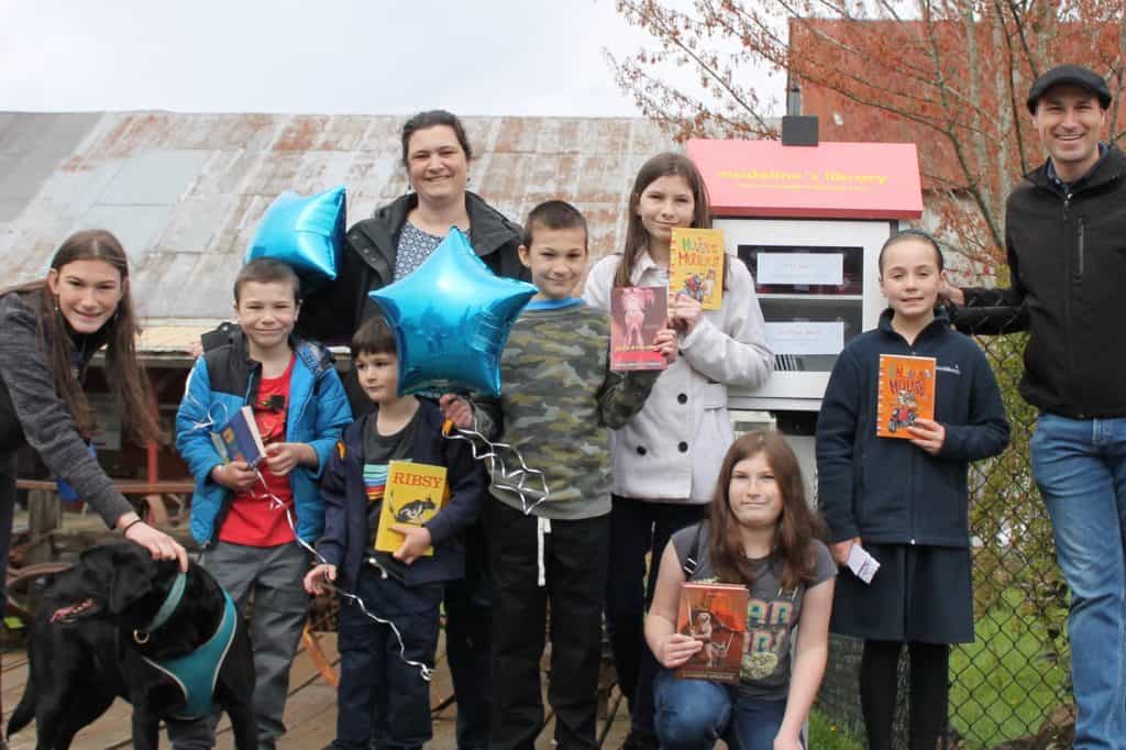 Family in front of lIttle library in Yamhill, Oregon.