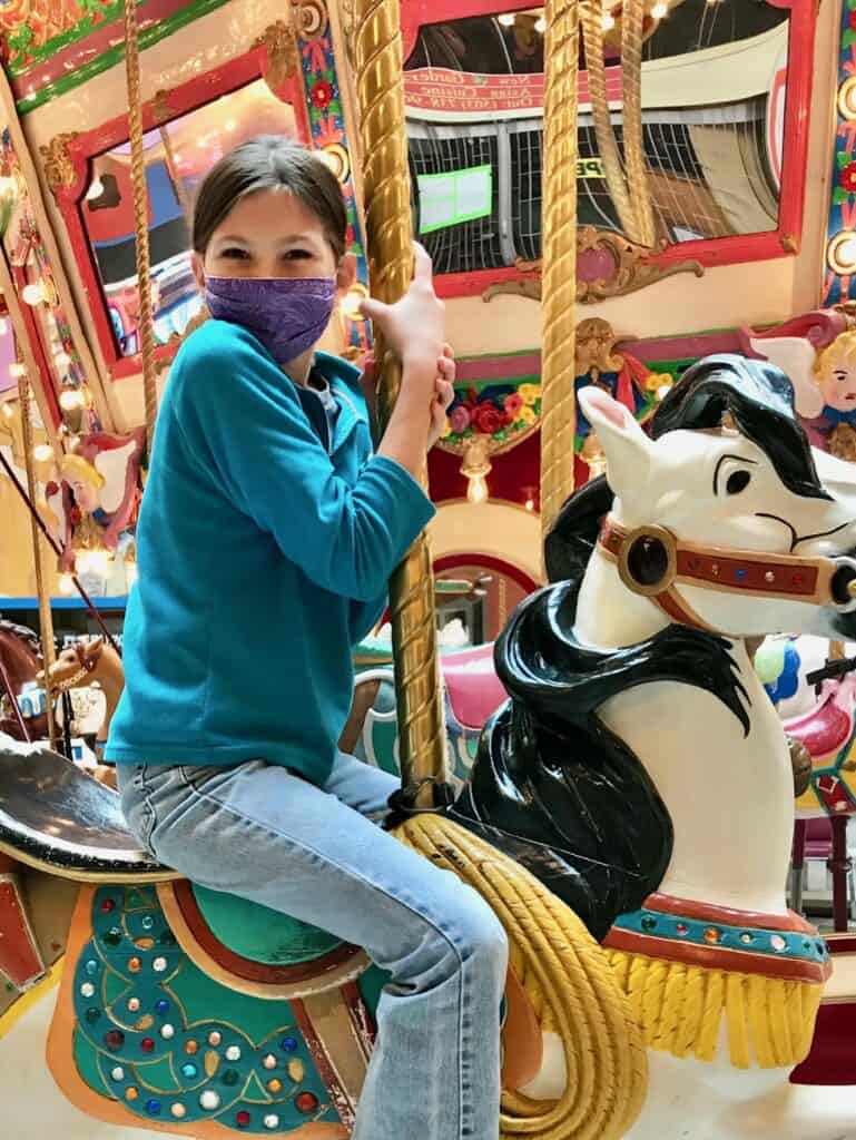 Girl on a carousel horse at the Seaside Carousel Mall.