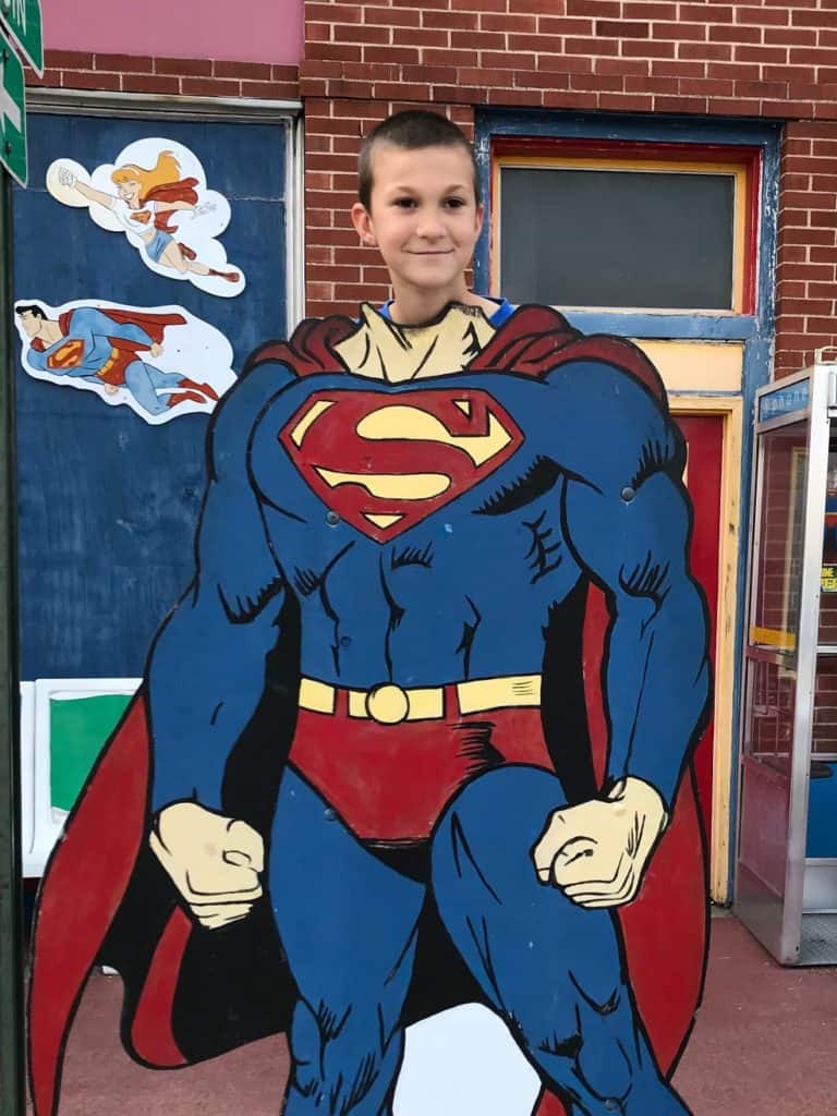 Boy behind Superman cutout. Executive dysfunction can be an ADHD superpower, or it can be like kryptonite.