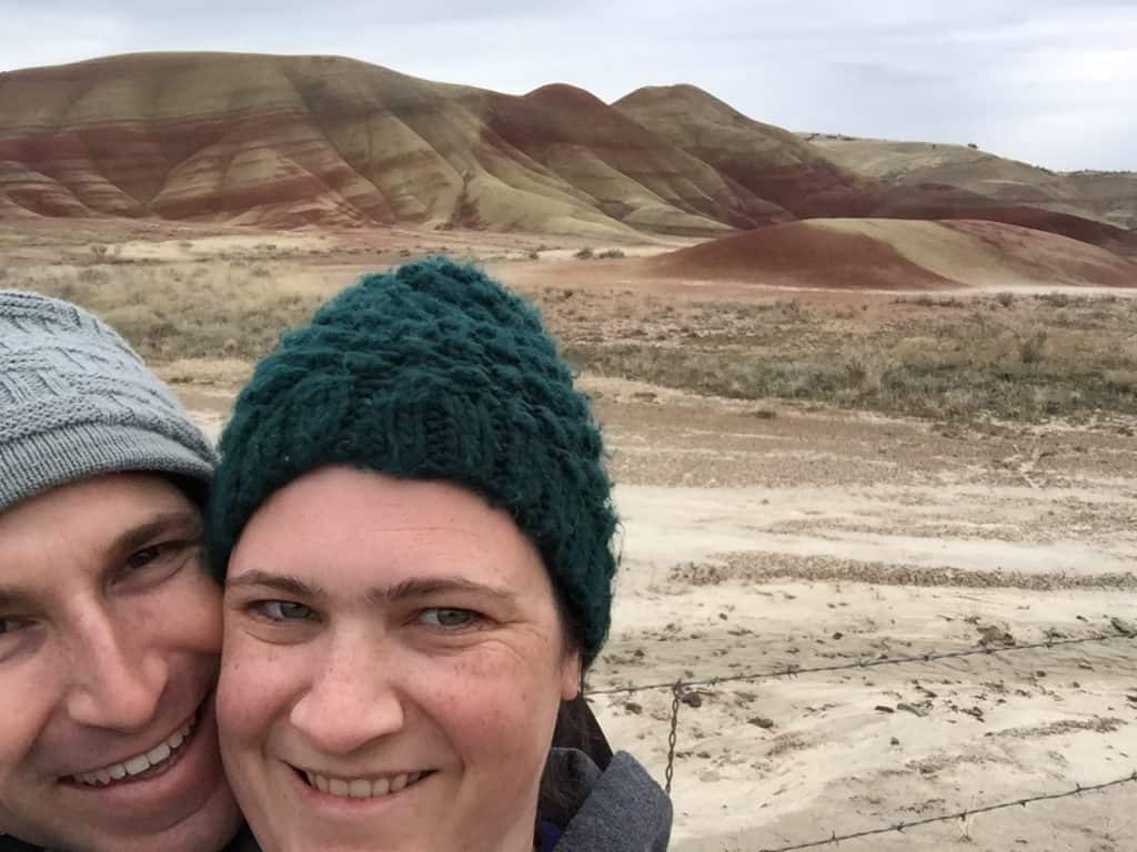 Couple with beanies in front of the Painted Hills National Park (John Day Fossil Beds National Monument - painted hills unit).