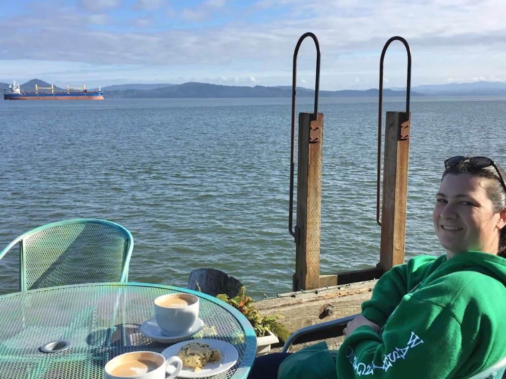 Sitting on the pier at Coffee Girl in  Astoria. When visiting Astoria Oregon with kids, we recommend coffee girl as a great breakfast with a view.