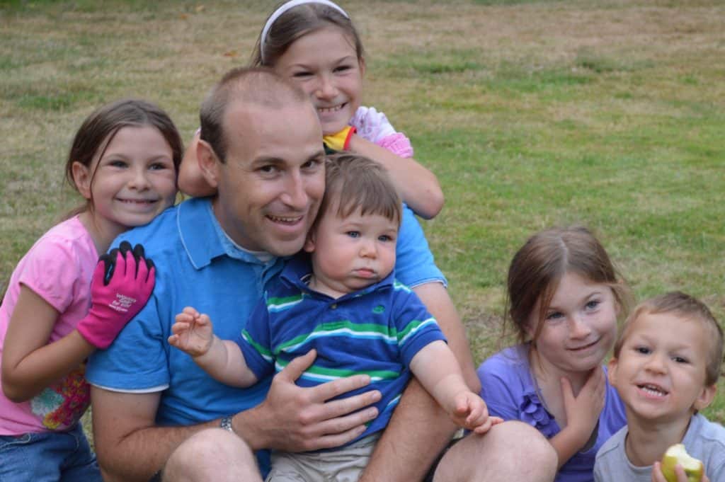 Man surrounded by 5 children. ADHD often runs in families. 