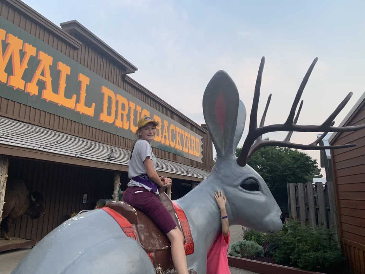 Weird and wonderful Wall Drug. Girl on a giant jackalope. Get your photo ops at one of the only restaurants in Badlands National Park.
