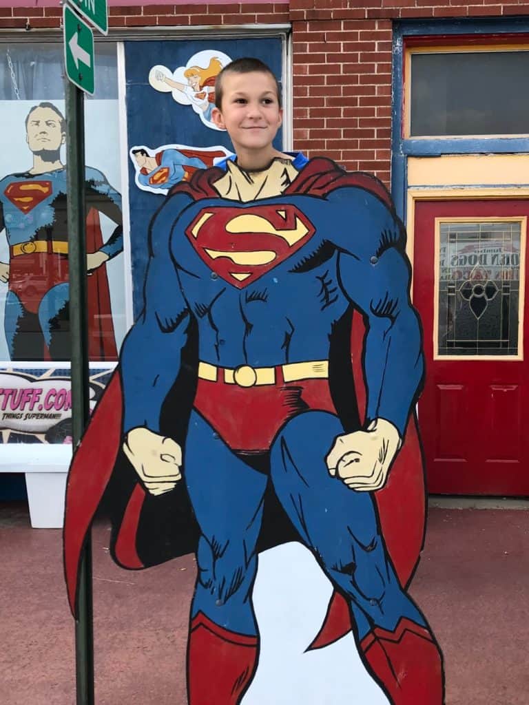 Boy behind a Superman cutout. ADHD strengths can be like superpowers: great when used appropriately. 