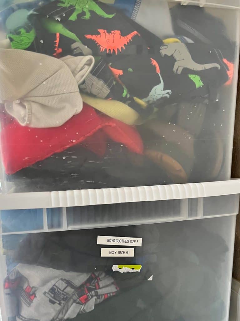 Boys clothing in plastic storage tubs. Read on for more kids clothing organization ideas.