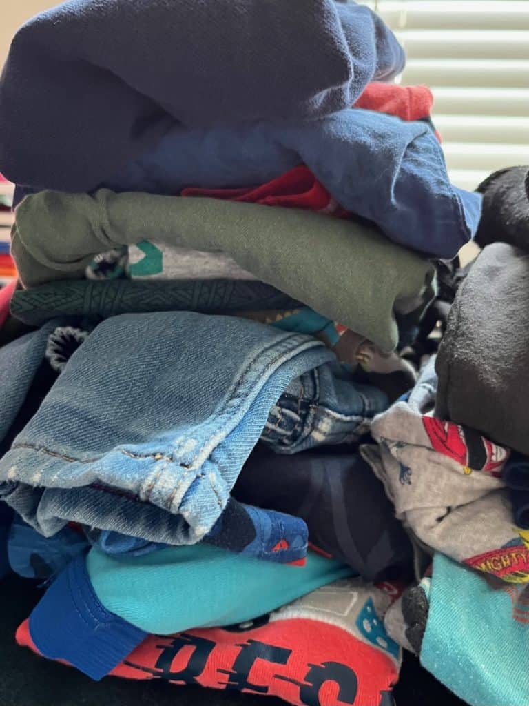 Kids clothes folded and stacked. Read on for more kids clothing organization tips.