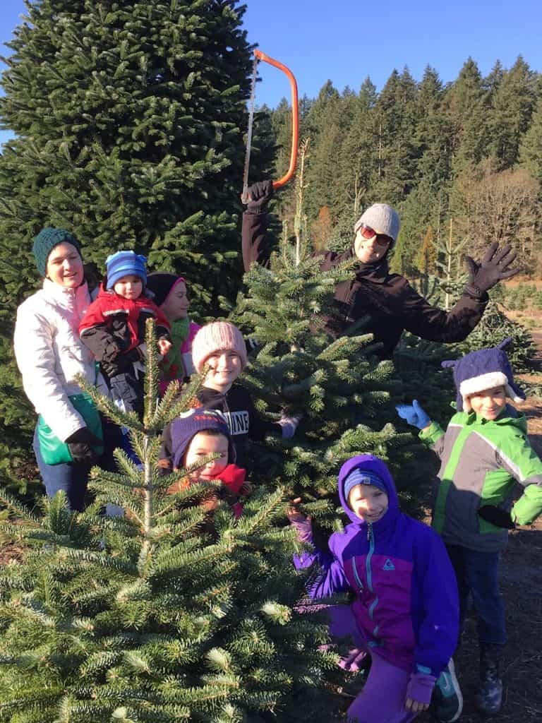 Family with Christmas tree at a Christmas tree farm. Many of the pumpkin patches in the Salem, Oregon area double as Christmas tree farms.