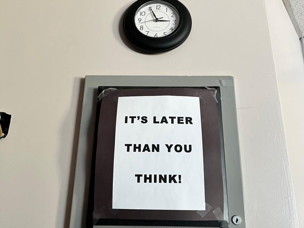 Wall clock with sign below that reads: "It's Later than you think!" Sleep Help for ADHD and anxiety.