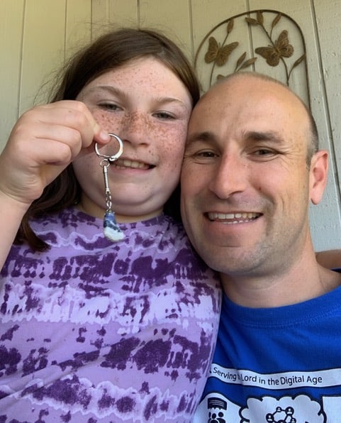 Me celebrating with my daughter. She hold a keychain decorated with a sodalite stone that she had polished using her rock tumbler.