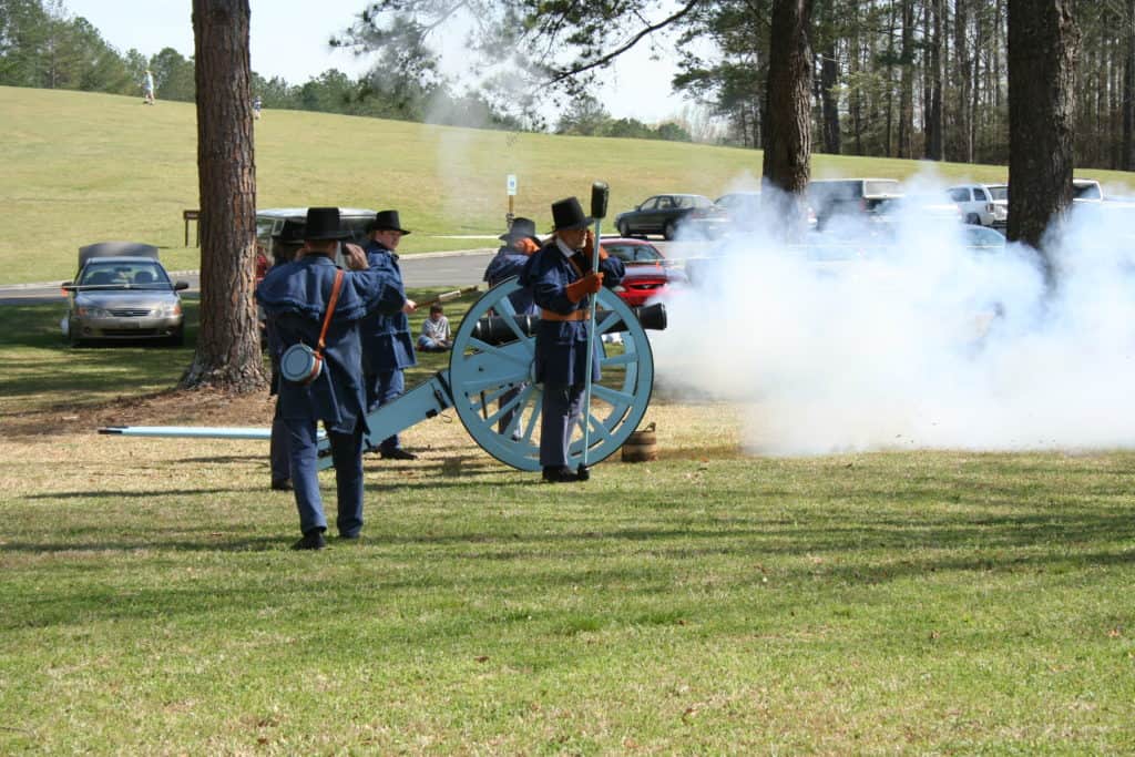 Soldiers firing a cannon as part of a historical reenactment at Horseshoe Bend National Military Park in Alabama, one of the best national parks in Alabama. Image courtesy NPS.