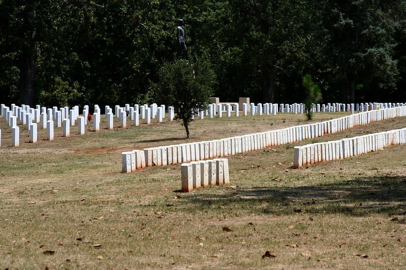 Six military tombstones stand at a distance from all the other rows of tombstones at Andersonville National Historic Site. Andersonville NHS is one of the 12 Best National Parks in Georgia.