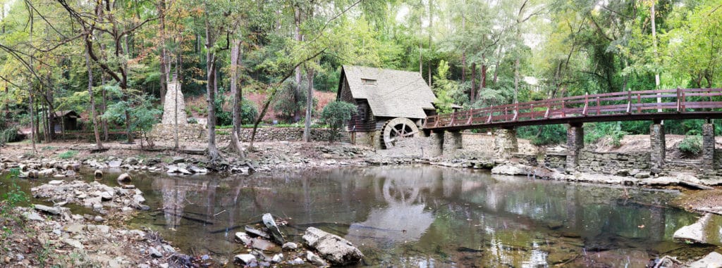 A mill and waterwheel stand across the creek from Jemison Park.