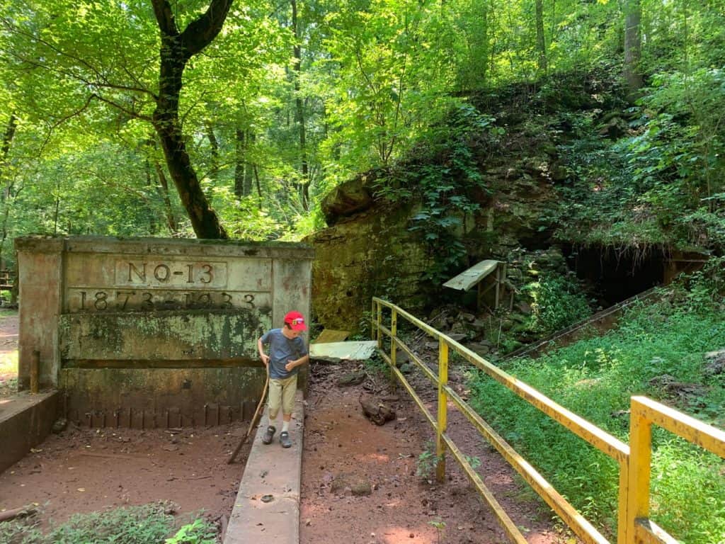 My son walks along the entrance of the No-13 Mine at Red Mountain. A large yellow fence keeps him away from unseen mine hazards on the hillside.