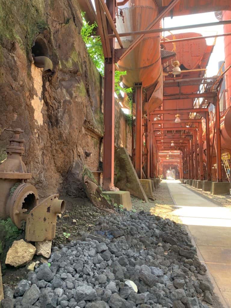 A flat, cement pathway leads through the maze of enormous pipes and machinery found at the Sloss Furnaces. Sloss Furnaces is one of the 17 best hiking trails Birmingham AL.