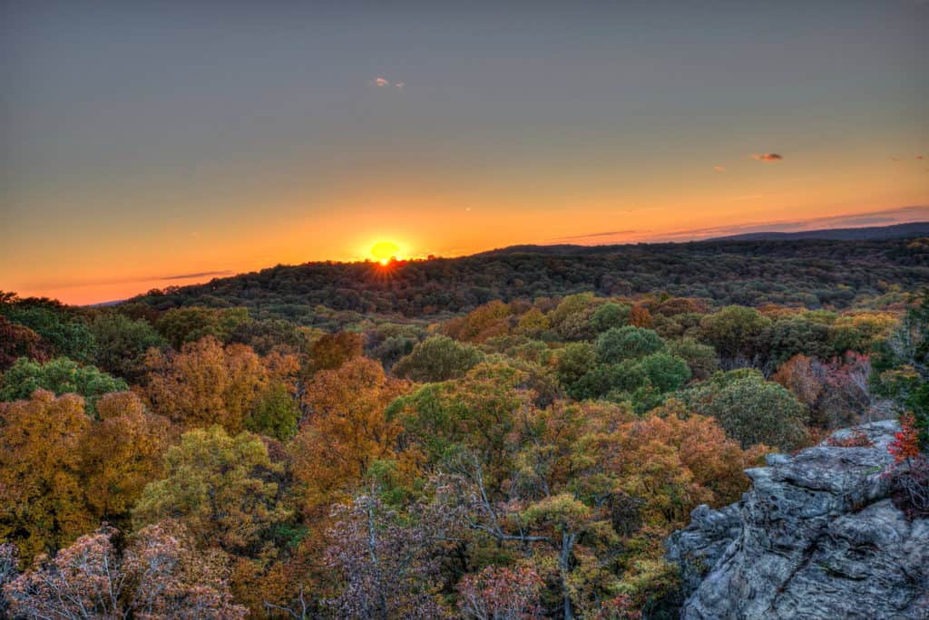 The sun peaks over the horizon as seen from the Garden of the Gods in Southern Illinois.