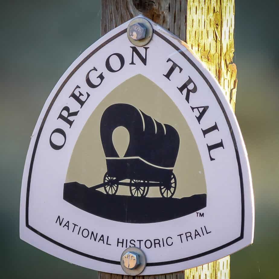 A national trails sign depicts a covered wagon with the words "Oregon Trail National Historic Trail." Oregon National Historic Trail is one of the 19 best national parks in Oregon and Washington.