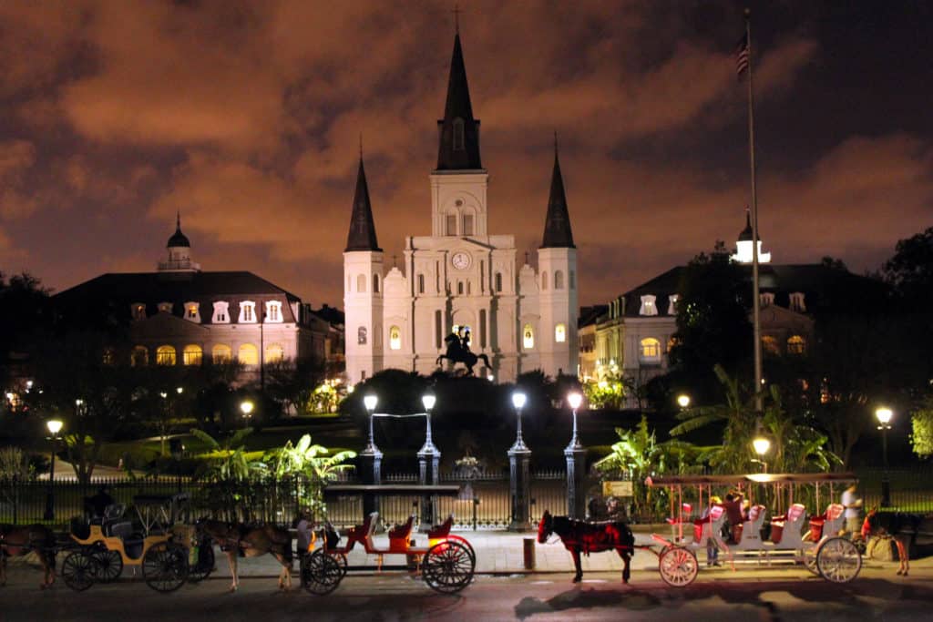 St. Louis Cathedral stands lit up behind Jackson Square in historic New Orleans. You can visit places where history was made on Dinkum Tribe's List of National Parks and Monuments by State.