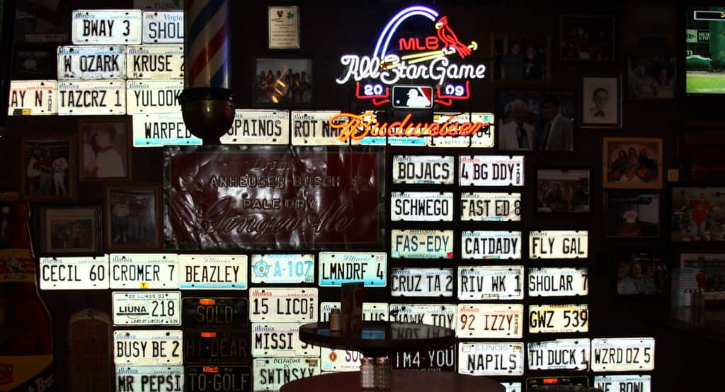 Neon signs, photos, and a collection of vanity plates decorates a wall at Fast Eddie's Bon Air.