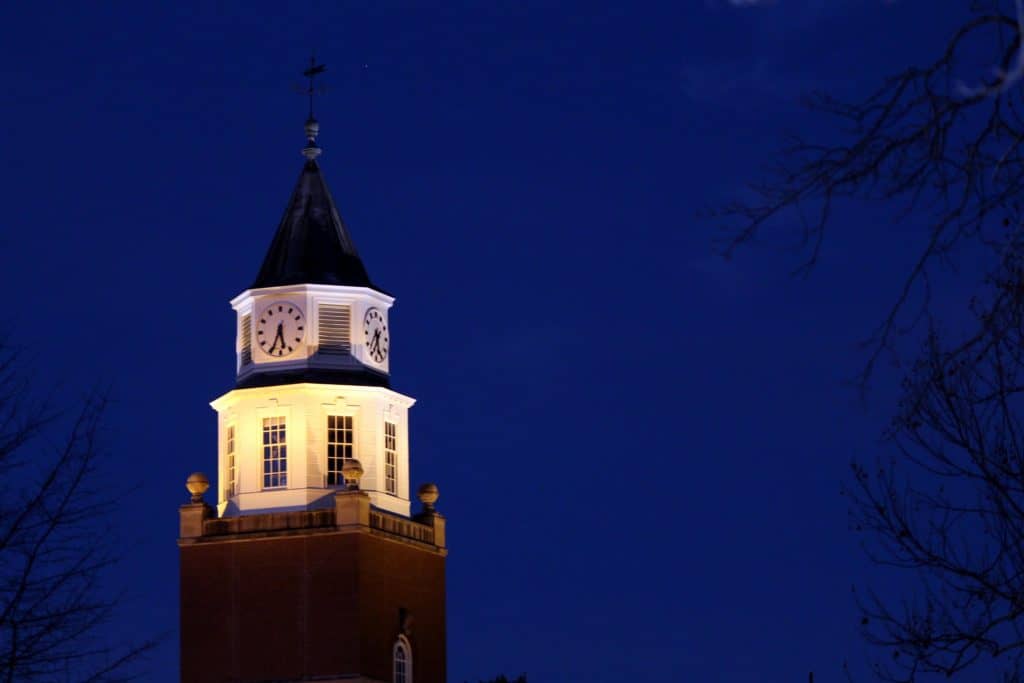 Southern Illinois University's bell tower stand watch in the early evening moonlight.