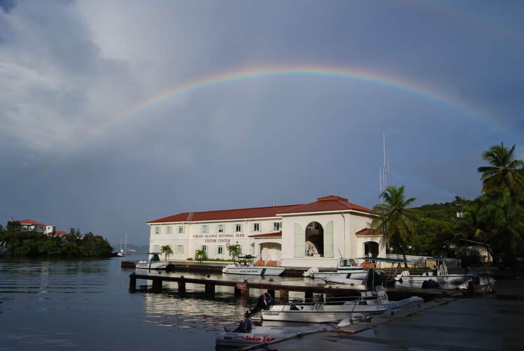 A rainbow frames the bayside visitor center of Virgin Islands National Park. All five of the national parks found on the Virgin Islands can be found on Dinkum Tribe's list of national parks and monuments by state. Image by NPS.