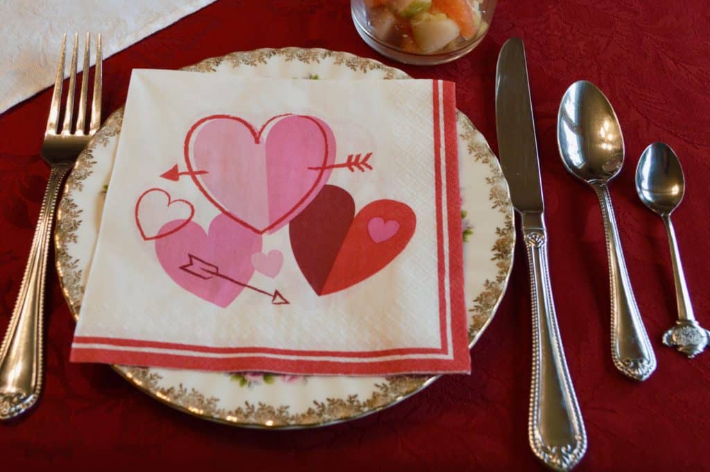 Valentine's Day table setting with paper heart napkin.