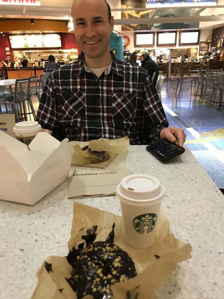 Man enjoying Starbucks and a donut at PDX. Date Night for Married Couples.