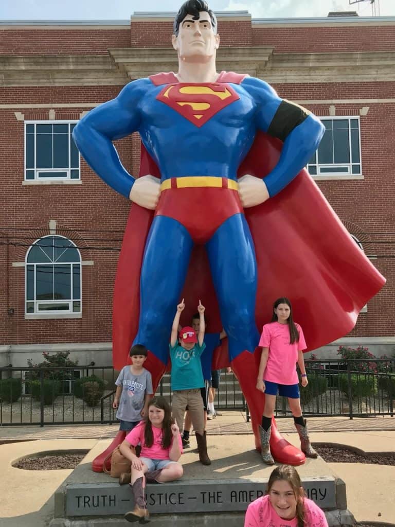 My six children pose next to the enormous Superman statue in Metropolis, Illinois. Metropolis' Superman District is one of the 37 best things to do in Southern Illinois.