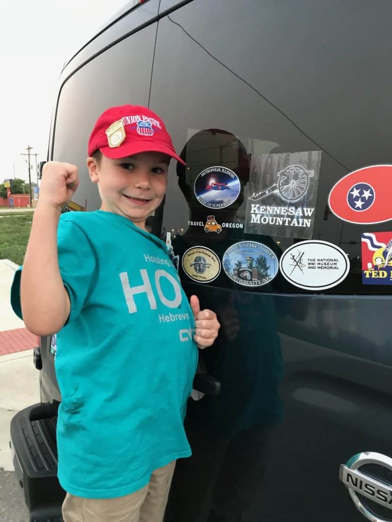 My son flexes his muscles after adding a Metropolis bumper sticker to our quickly-growing collection.