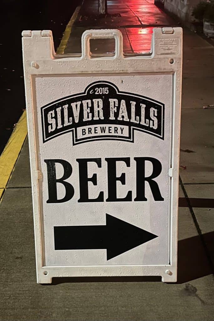 A sandwich board sign says "Beer". A large arrow under the word "Beer" points people into the Silver Falls Brewery Restaurant in Silverton, Oregon.