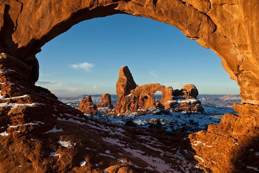 Snow glazes the bizarre landscape of Arches National Park. Arches National Park is one of the best national parks to visit in November and December.