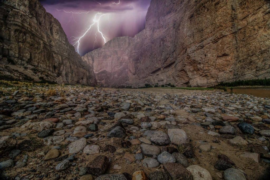 Lightning flashes over a canyon at Big Bend National Park. Big Bend National Park is one of the best national parks to visit in November and December.