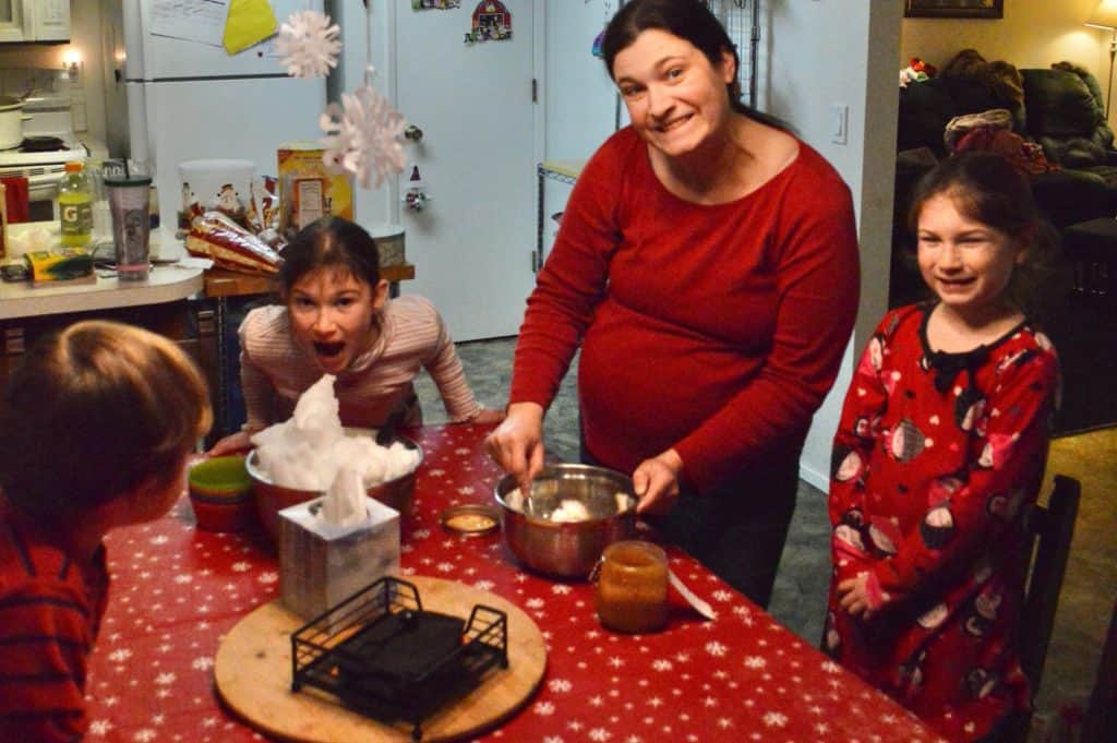 Mom and children making snow cream at the table.