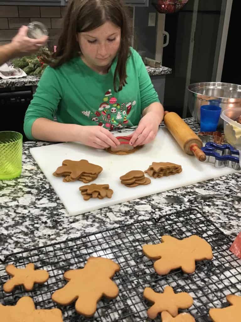 Girl baking gingerbread cookies. Family Christmas bucket list.