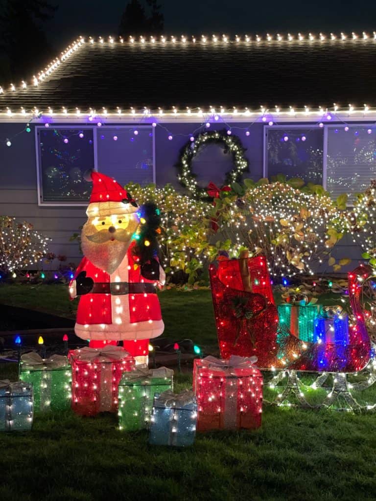 An inflated Santa stands among all kinds of Christmas lights at a house in Keizers Miracle of Christmas display. The Miracle of Christmas is one of the 11 best places to see Christmas lights in Salem Oregon.