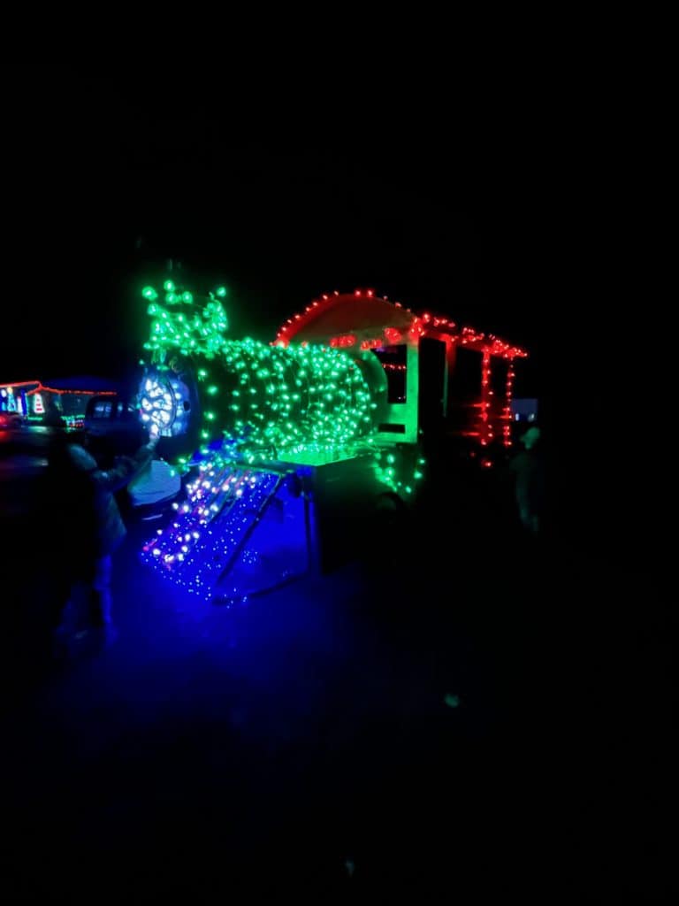 Train decorated with Christmas lights at night.