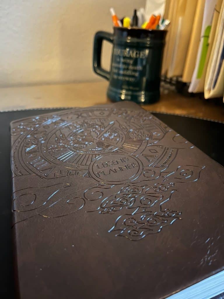Picture of a brown Legend planner sitting at a writing desk.