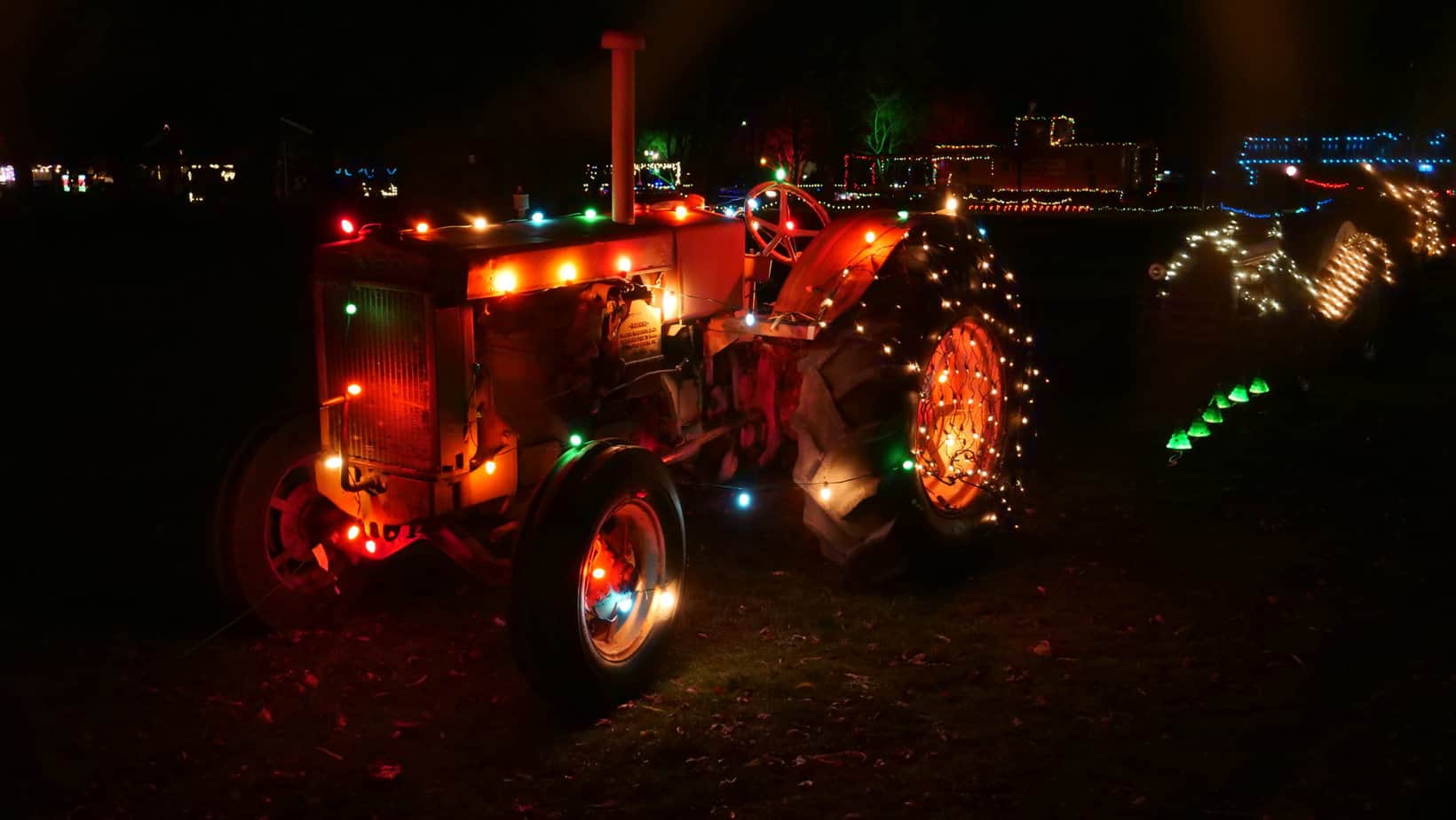 Christmas lights decorate a tractor, railcars, and other fun machines at Powerland's Holiday Sparkles event. Powerland Heritage Park is one of the 11 best places to see Christmas lights in Salem Oregon.