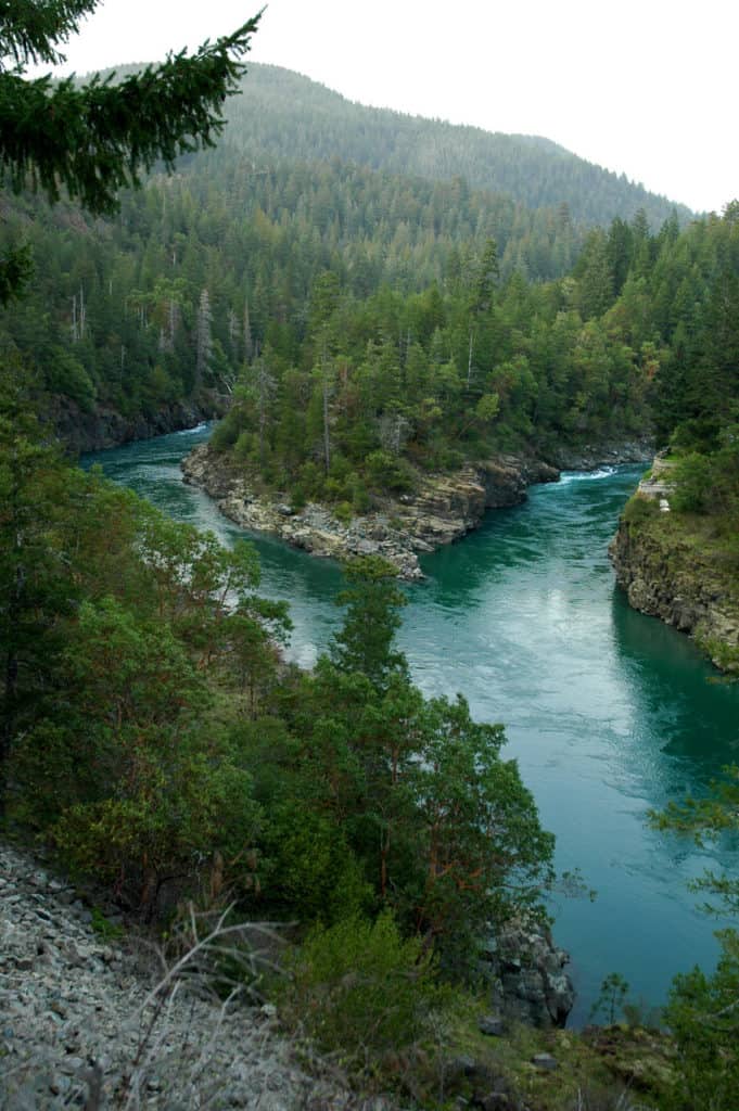 Pristine blue waters carve through forested mountain valleys at Smith River National Recreation Area.