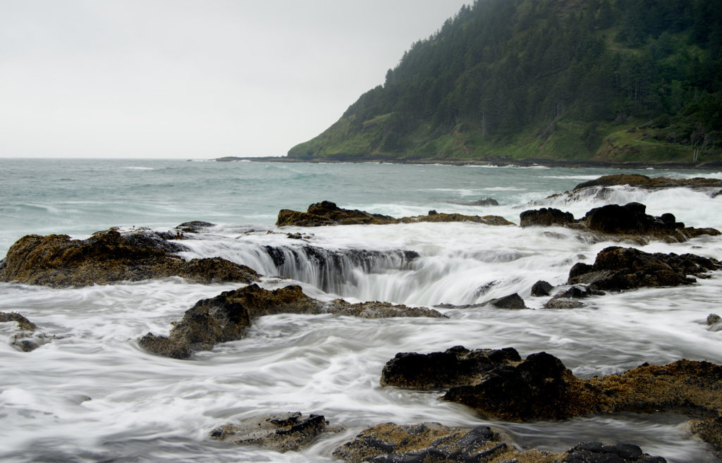 The ocean appears to drain away into Thors Well, a landmark at Cape Perpetua, Oregon.