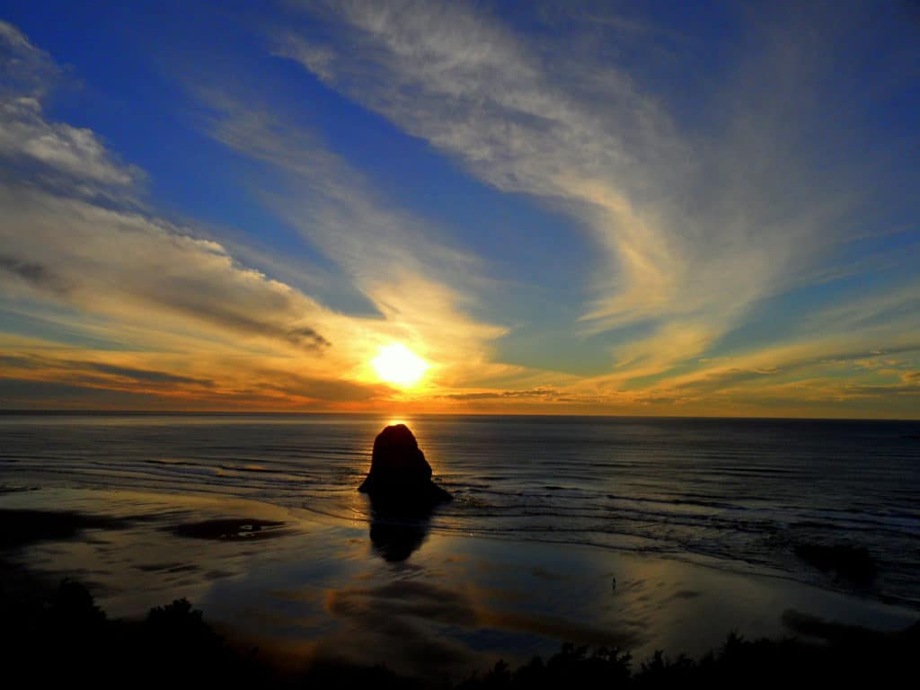 The setting sun tops a sea stack at Cannon Beach.