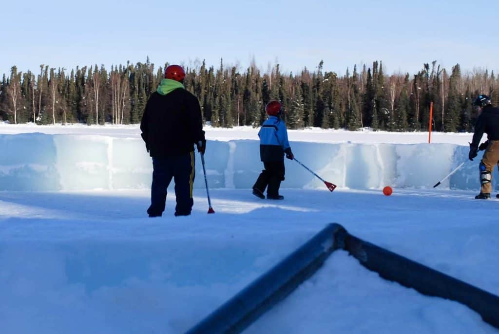 Broomball game on an ice rink. Winter activities for teens.