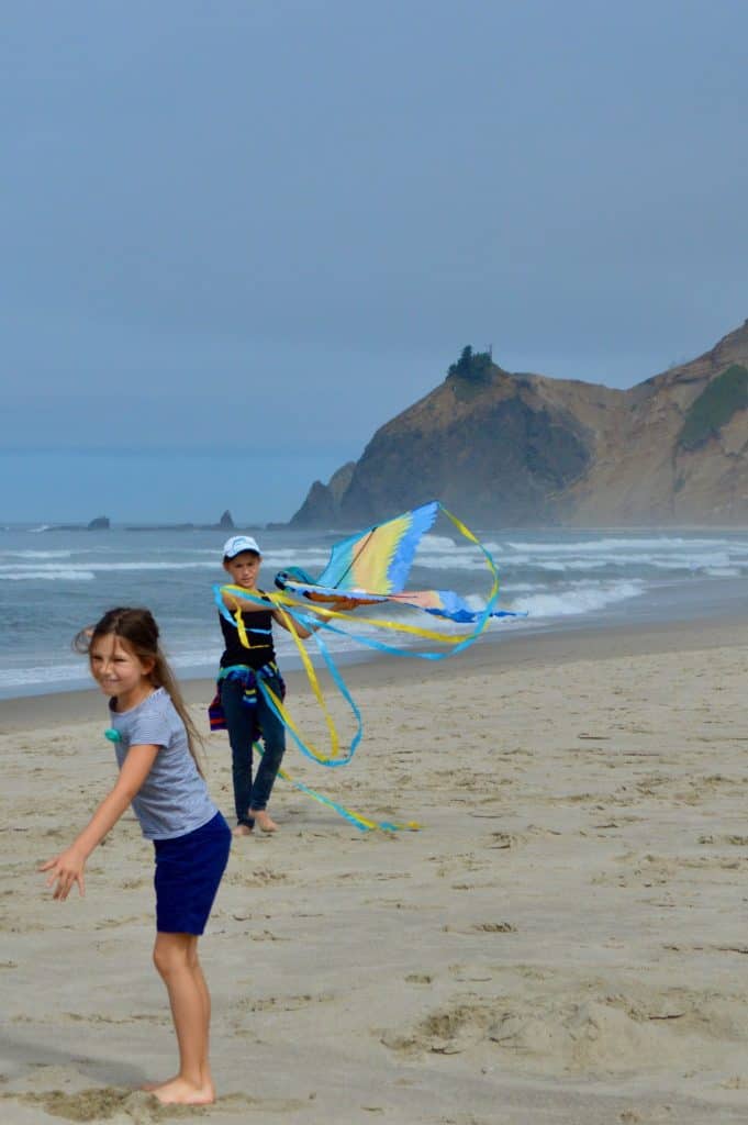 Girls playing with kite at the beach. Beach packing list family.