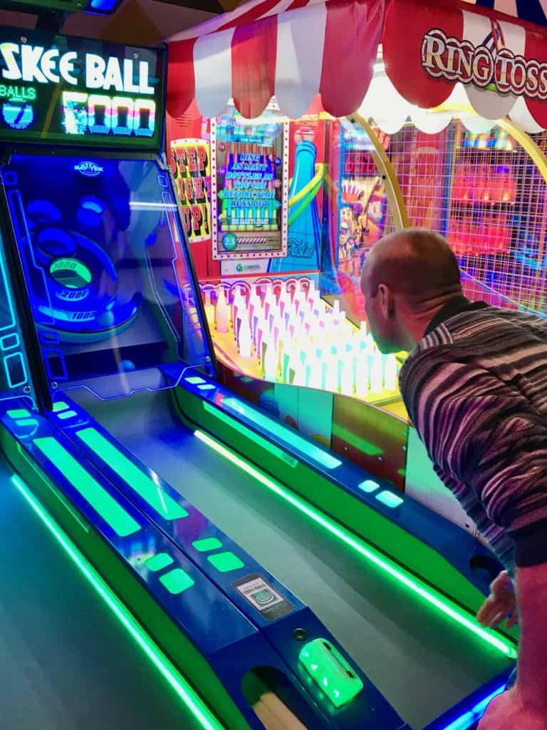 Man playing skeeball. Winter activities for teens.