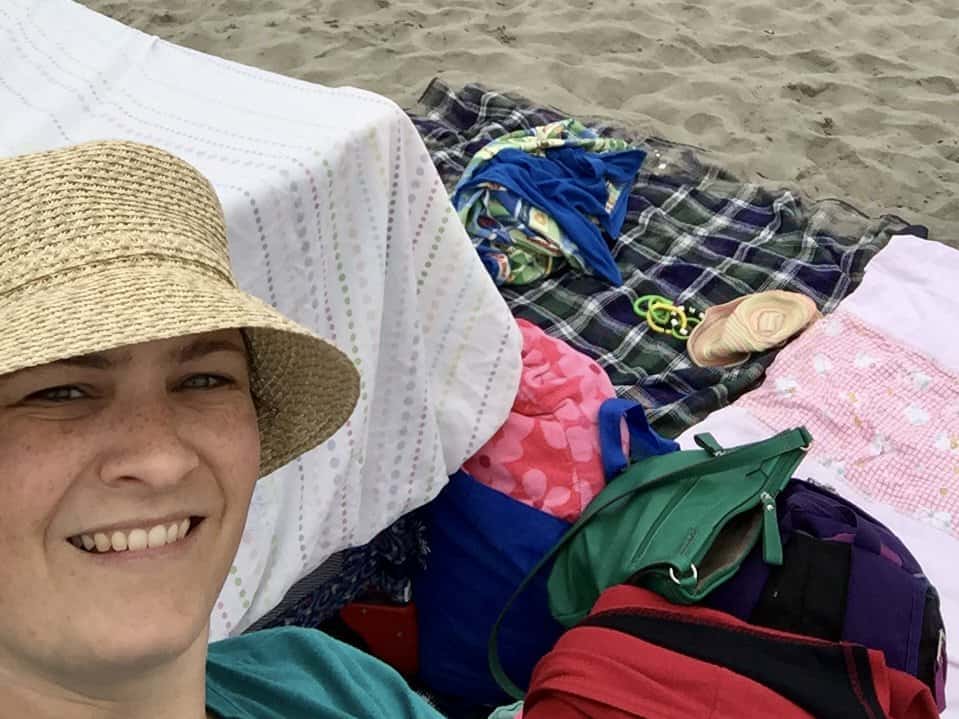 Woman at beach with gear. Beach packing list family.