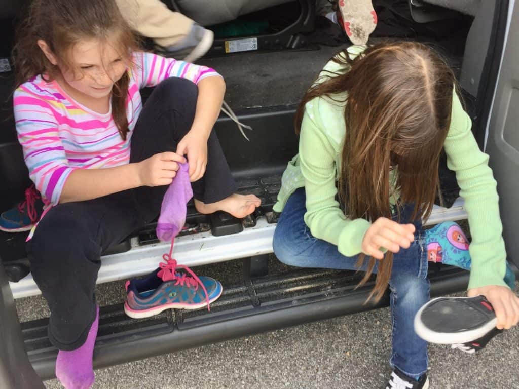 Girls putting on socks and shoes. Beach packing list family.