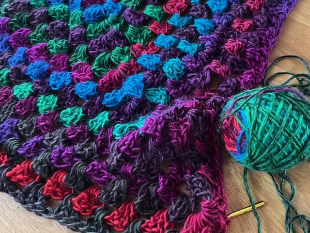 Crocheted blanket with needle and ball of yarn. Winter Activities for Teens.