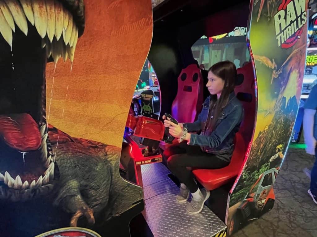 Teen girl playing jurassic park game. Winter activities for teens.