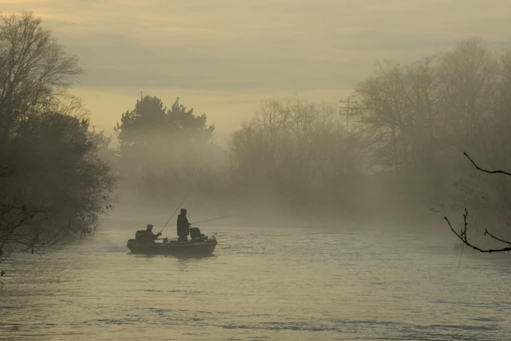 People fish from a small boat on a misty morning near Tillamook Oregon.